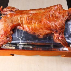 取机制炭2千克，放入烤羊炉，烧至炉内温度达到200---250度把全羊挂在炉内保持恒温200度左右，烤3.5小时至熟打开风门大火上